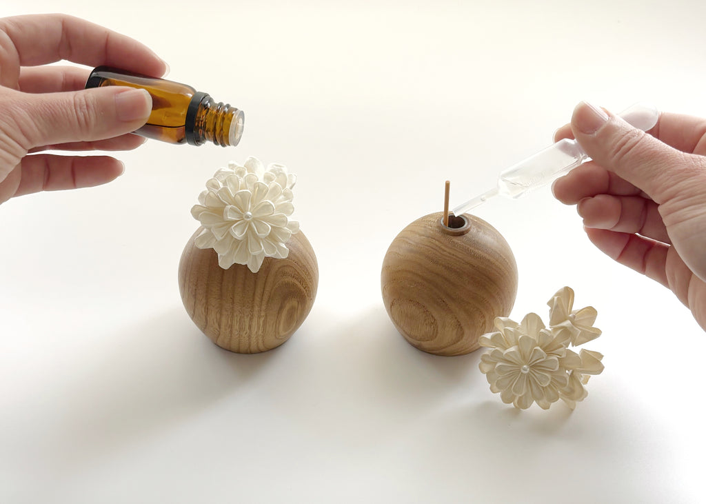 Applying essential oil onto Kaminoka Dual Single Flower Vase washi paper flowers on chestnut wood vases