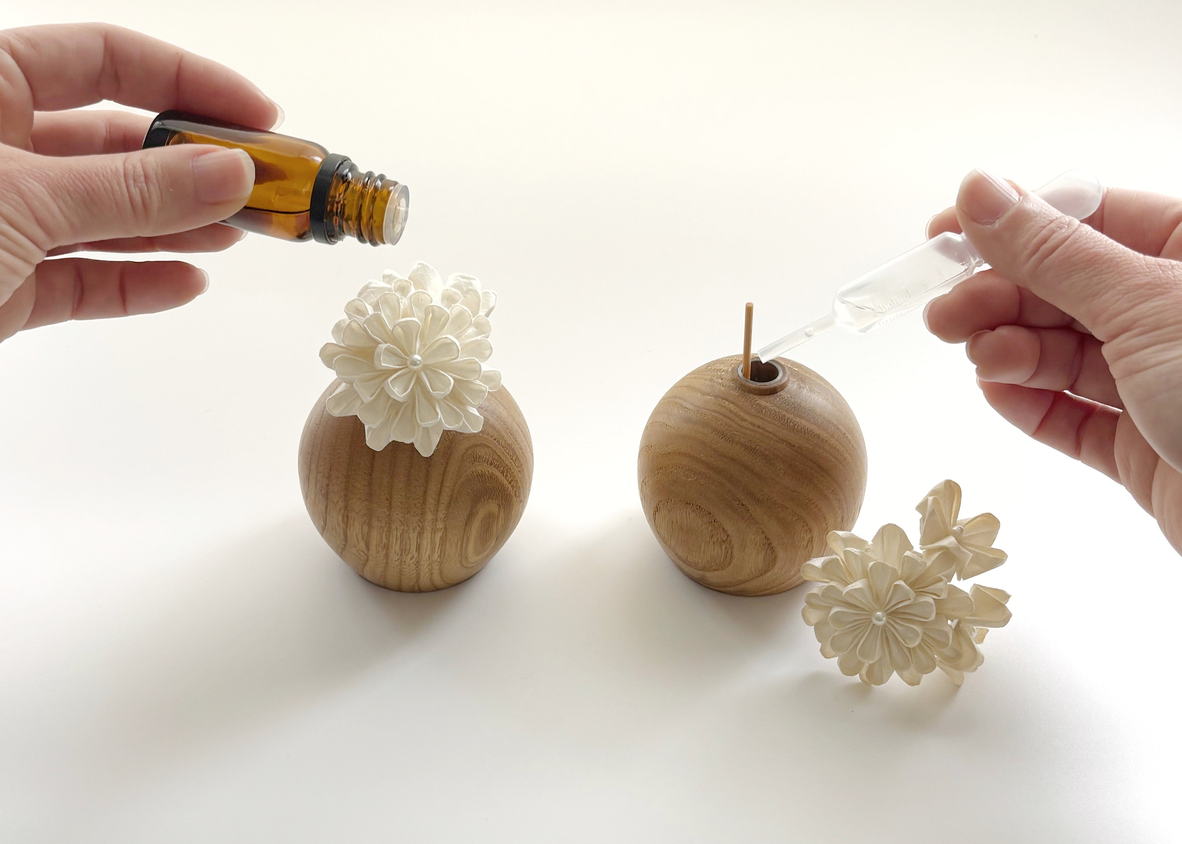 Applying essential oil onto Kaminoka Dual Single Flower Vase washi paper flowers on chestnut wood vases