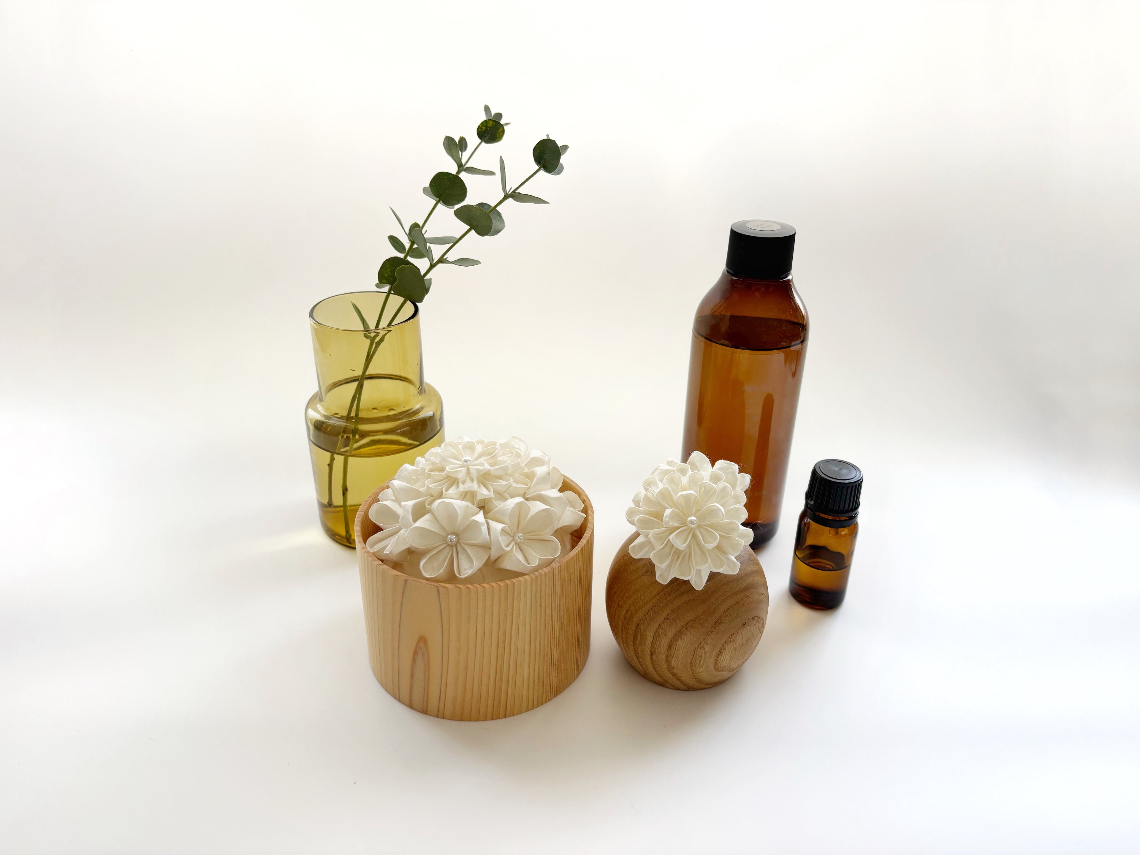 Kaminoka aroma diffuser lifestyle scene with paper flower baskets, essential oil bottles and glass vase