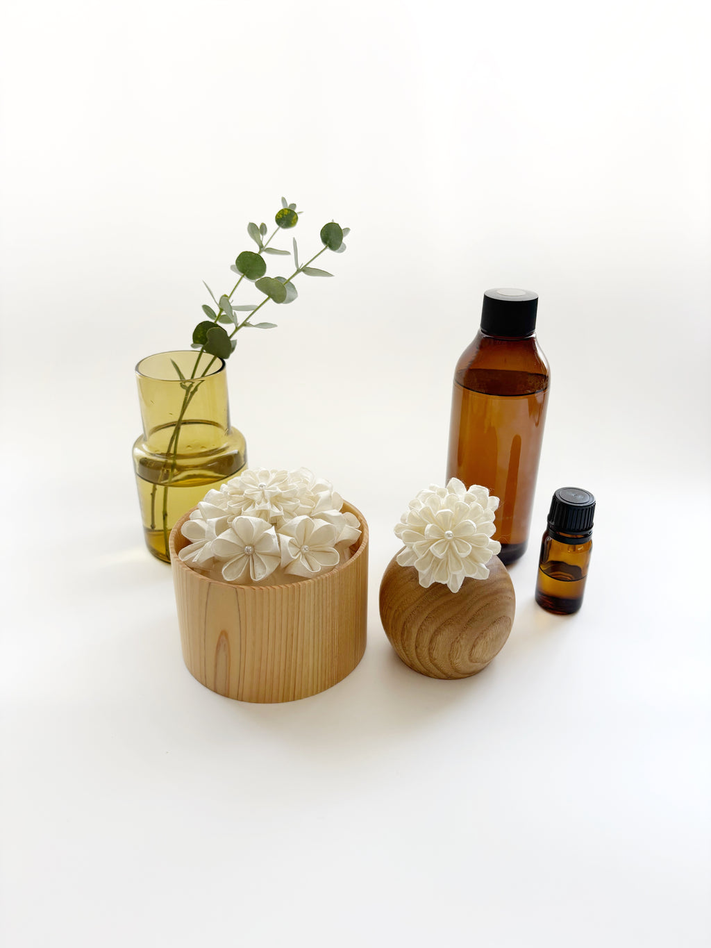 Kaminoka aroma diffuser vertical lifestyle with paper flower baskets, glass vase and essential oil bottles