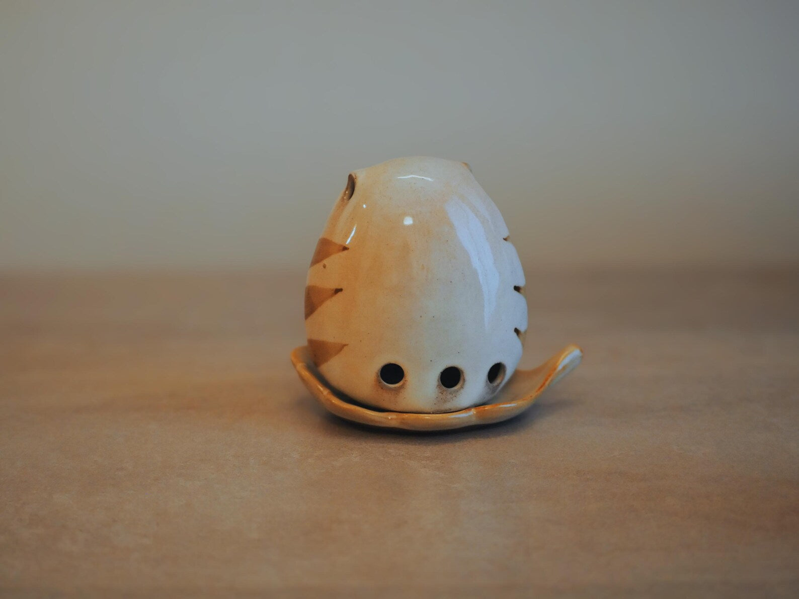 Japanese Owl Incense Stick Stand on neutral tan surface, lifestyle back view