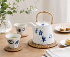 Shichifuku Dobin Teapot with sencha teacups on rattan mats and white tablecloth lifestyle scene