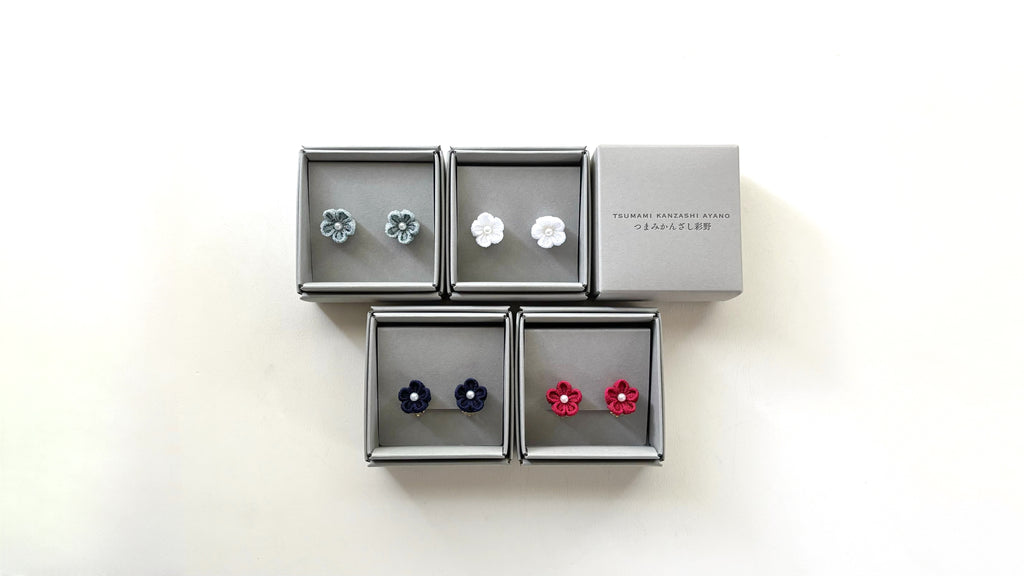Set of earrings in a display box on a white background