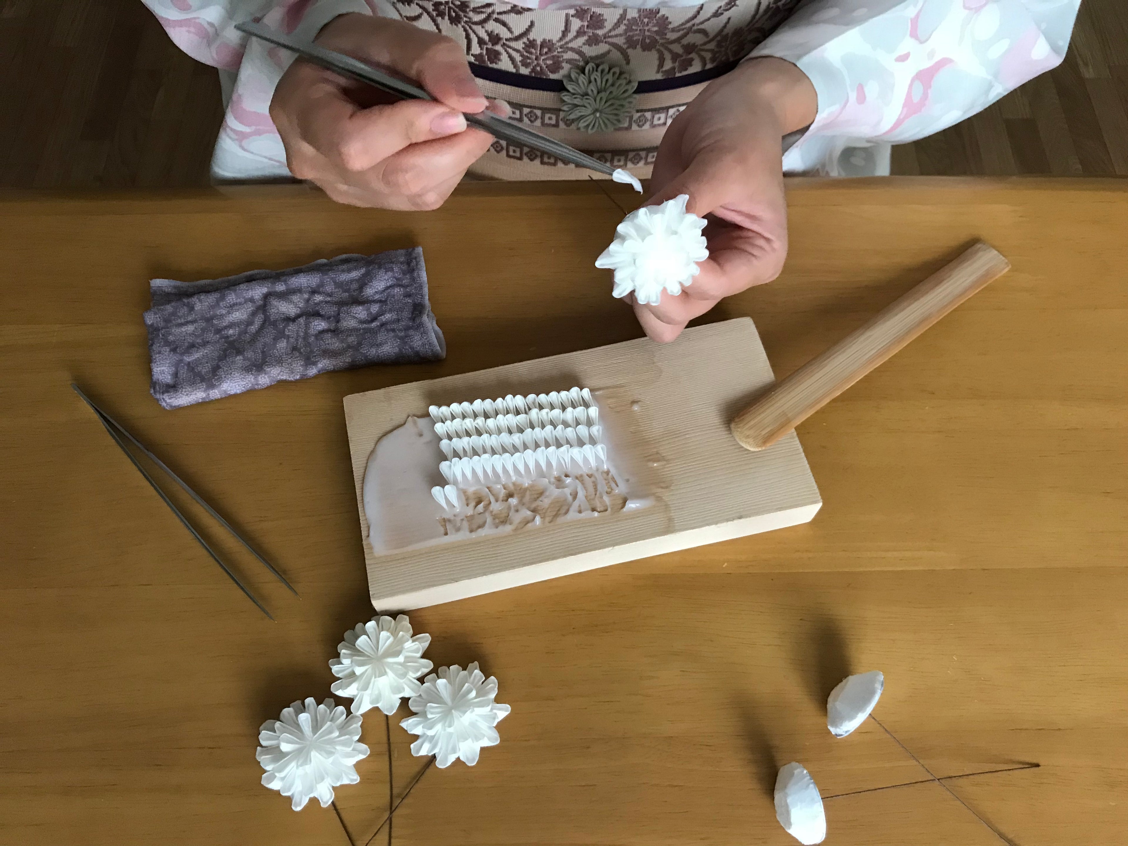 Person making decorative items with a mold on a wooden table