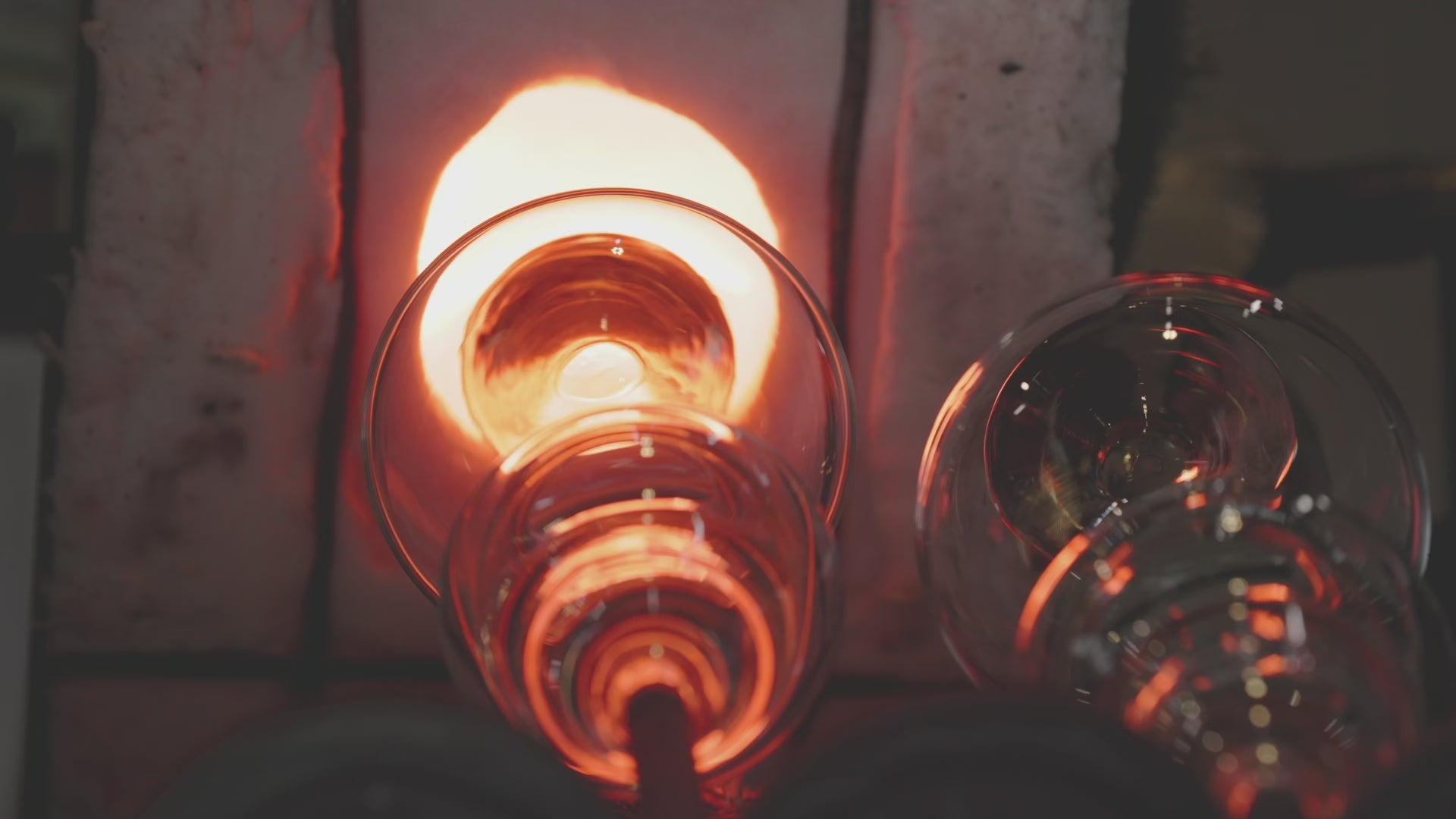 Artisan glassblowing process showing a master craftsman shaping a molten glass beer vessel in a high-heat kiln, authentic handmade glassware production.