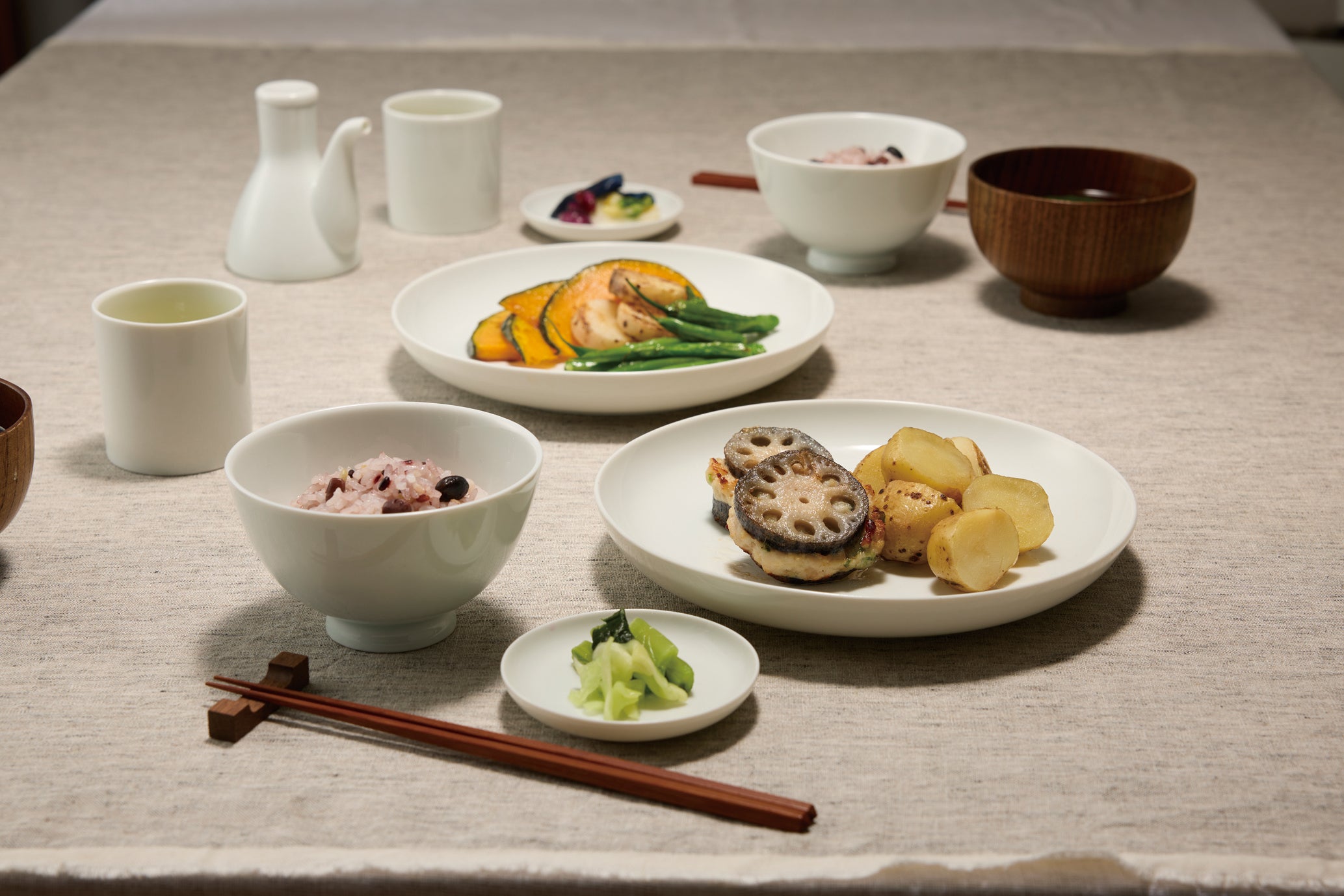 Full 7-piece Japanese Kobijiki white porcelain tea and dining set elegantly arranged with examples of traditional Japanese food.