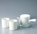 Two white **Japanese Yunomi** teacups displayed next to the matching **porcelain teapot** (kyūsu) on a solid background.