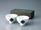 Pair of **Japanese porcelain rice bowls** with a footed base, decorated with the **blue and white Sometsuke swirl pattern**, displayed in front of the gift box.