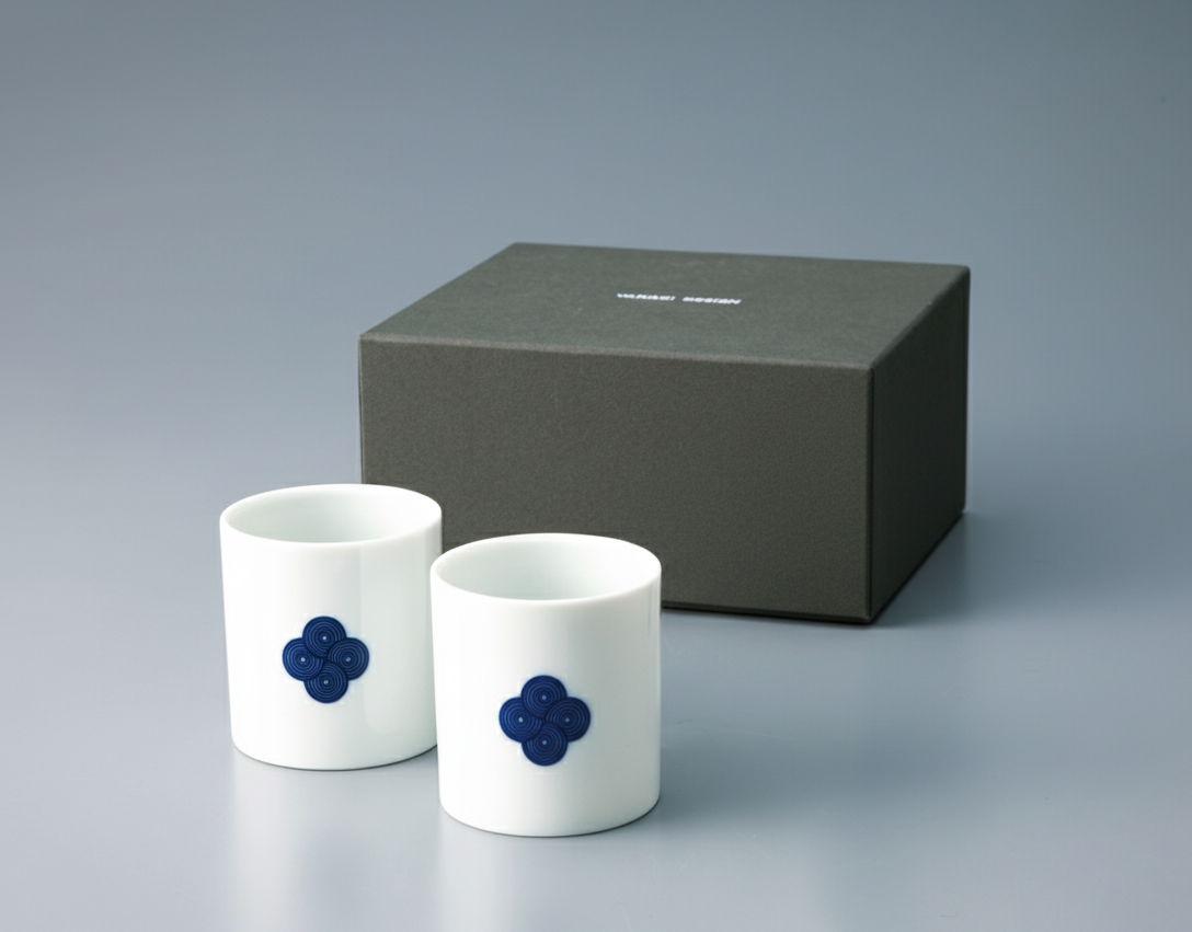 Pair of white **Japanese Yunomi teacups** with a **blue and white Sometsuke swirl pattern**, displayed next to the dark gray gift box.
