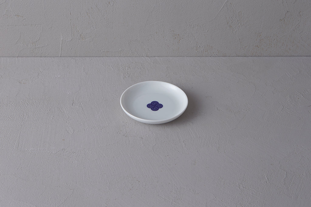 Small white **Japanese porcelain plate** featuring a single **blue and white Sometsuke swirl design** in the center.
