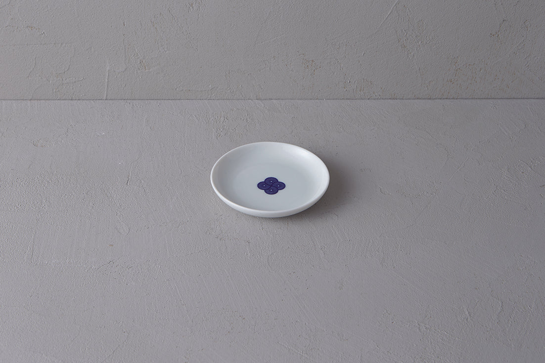 Small white **Japanese porcelain plate** featuring a single **blue and white Sometsuke swirl design** in the center.