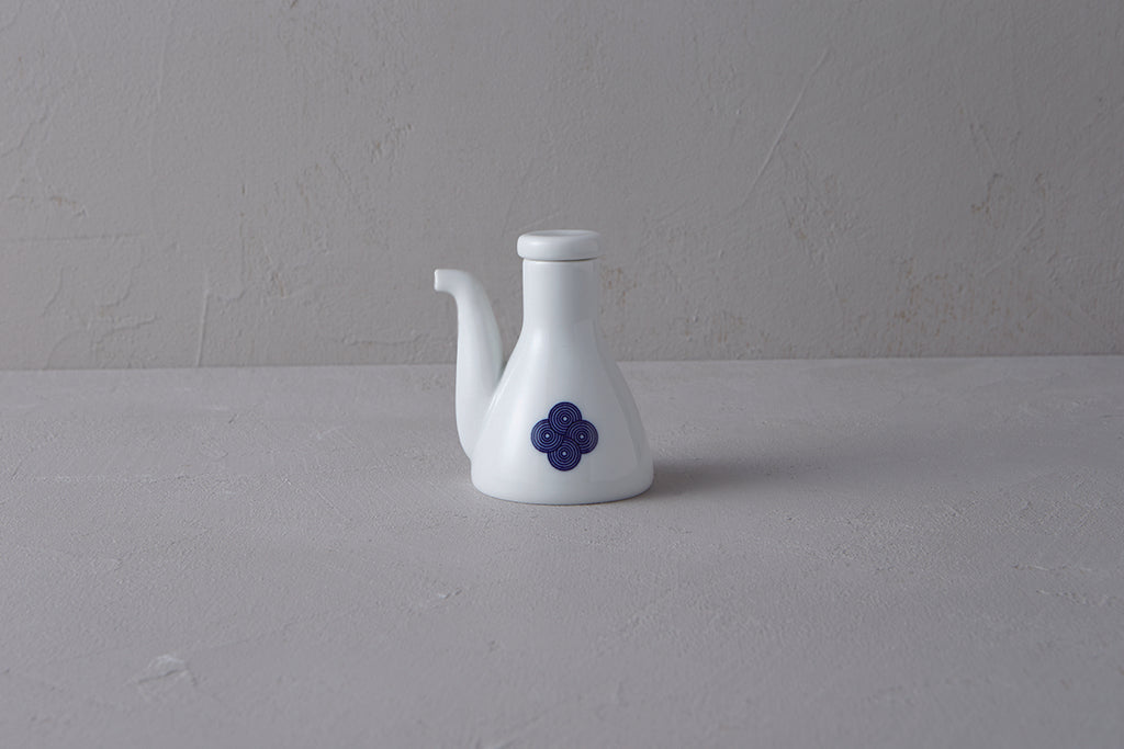 White Japanese **porcelain soy sauce pitcher** with a unique shape, decorated with a **blue and white Sometsuke swirl design** on the body.
