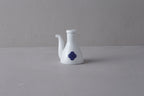 White Japanese **porcelain soy sauce pitcher** with a unique shape, decorated with a **blue and white Sometsuke swirl design** on the body.