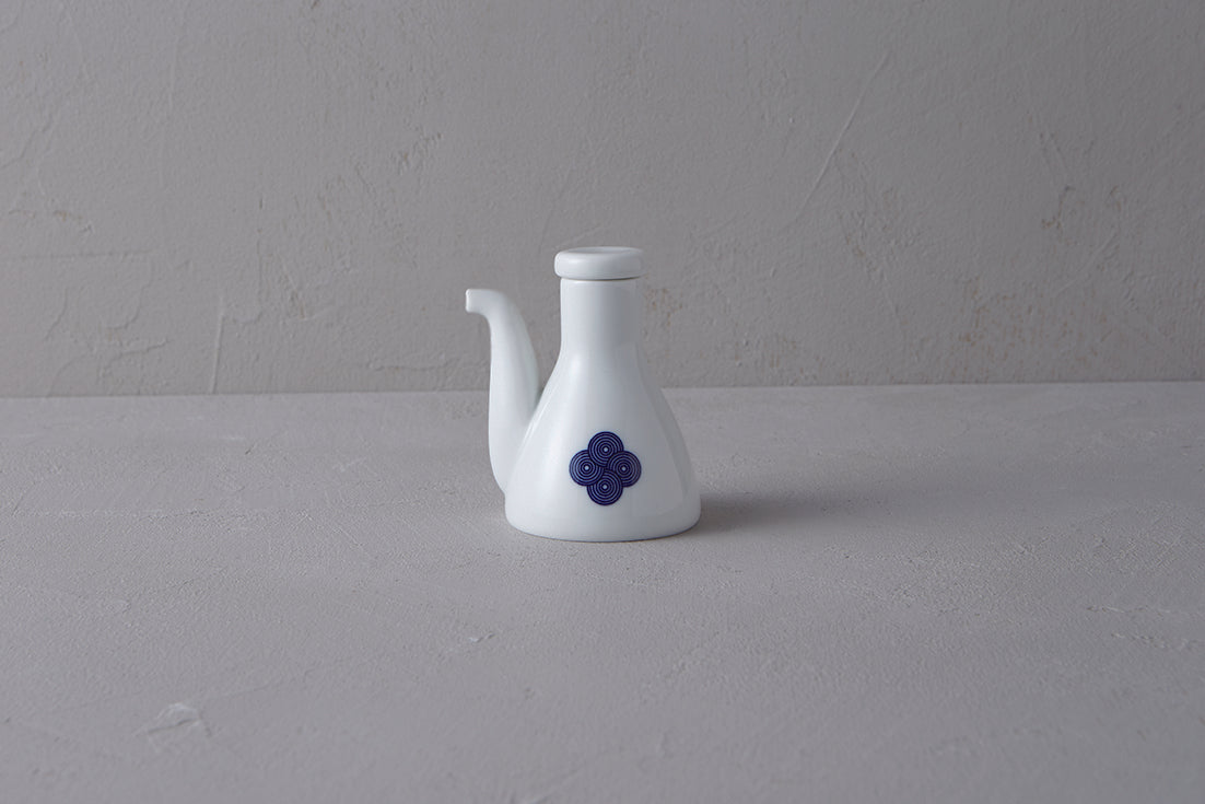 White Japanese **porcelain soy sauce pitcher** with a unique shape, decorated with a **blue and white Sometsuke swirl design** on the body.